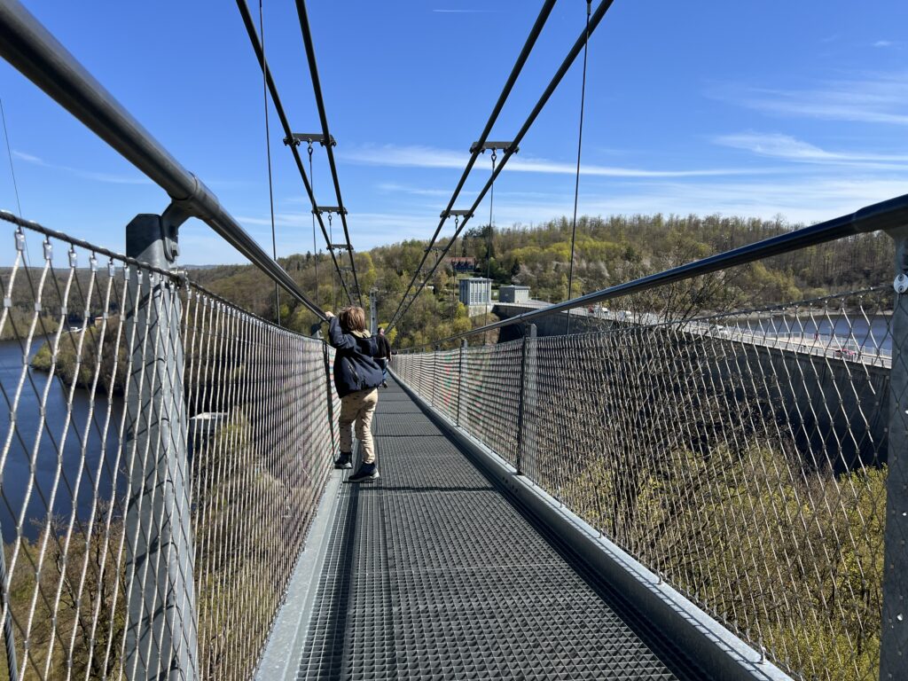 Kind kijkt naar beneden vanaf de Titan RT hangbrug in de Harz tijdens de meivakantie