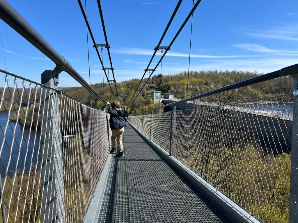 Kind kijkt naar beneden vanaf de Titan RT hangbrug in de Harz tijdens de meivakantie