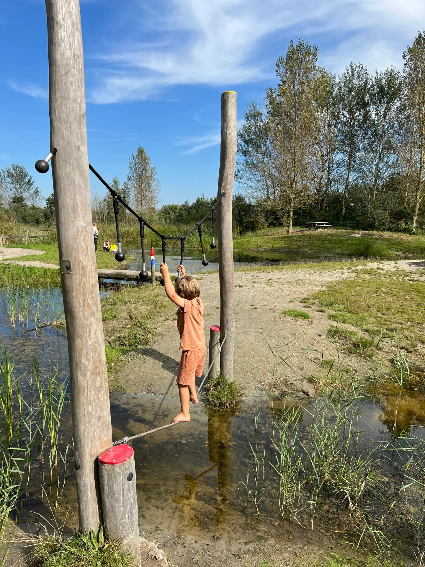 Kind speelt in de natuurspeeltuin bij het bezoekerscentrum Lauwersnest in Lauwersoog